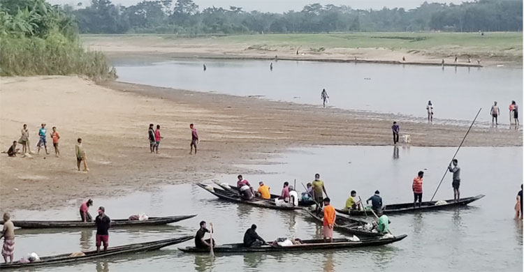 মনু নদে নৌকায় করে জেলেরা মাছ ধরছেন