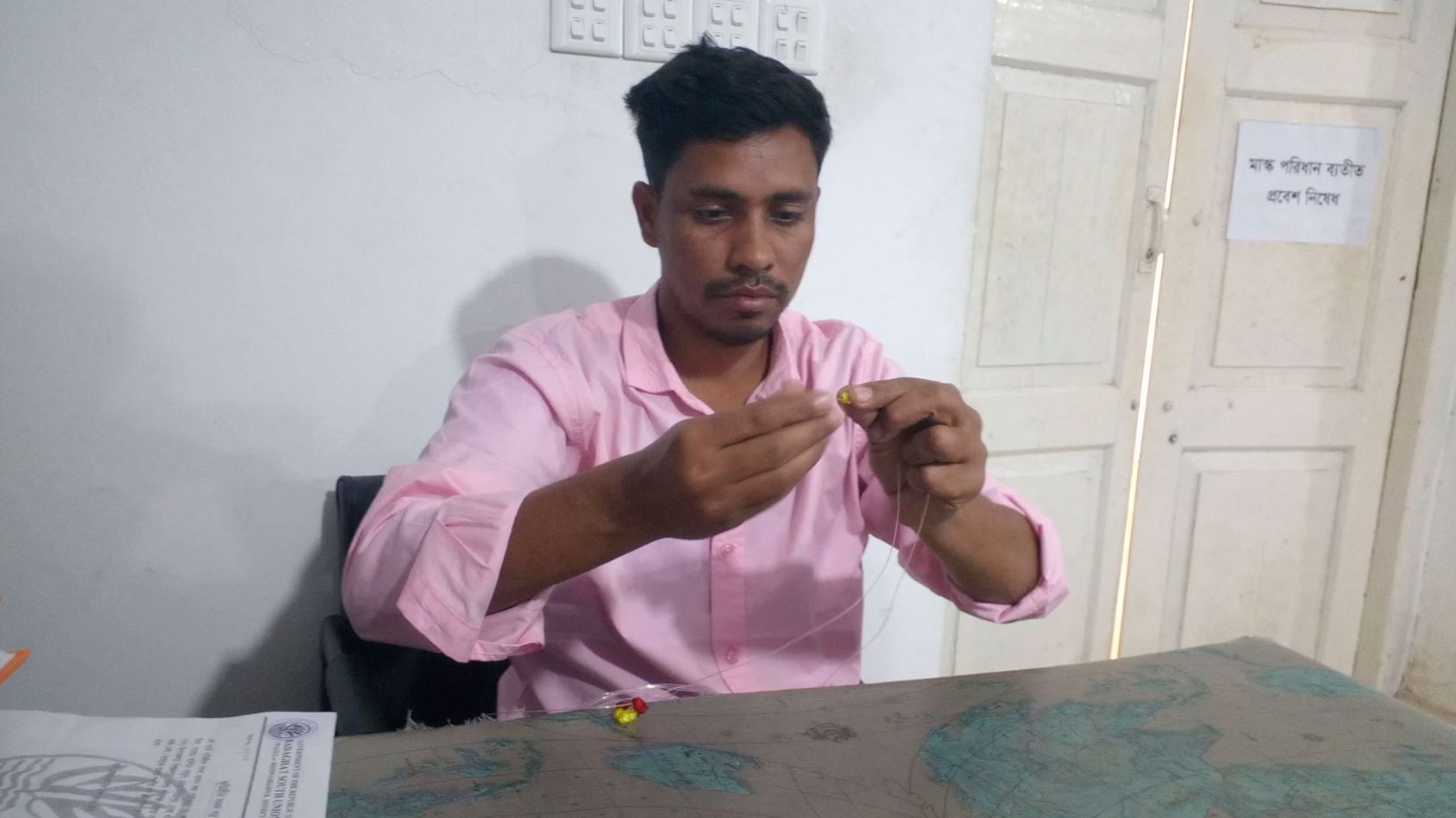 পুঁতি নিয়ে কাজ করছেন কাউছার