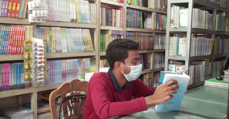 ক্রেতা নেই, তাই বই পড়ে সময় কাটানো
