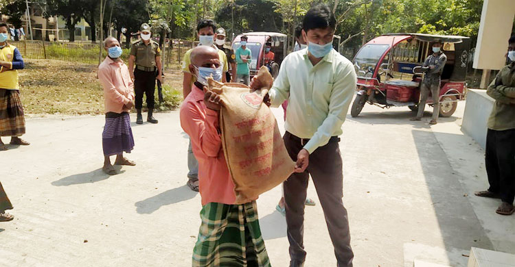 ক্ষতিগ্রস্তদের শুকনা খাবার দিচ্ছেন ইউএনও